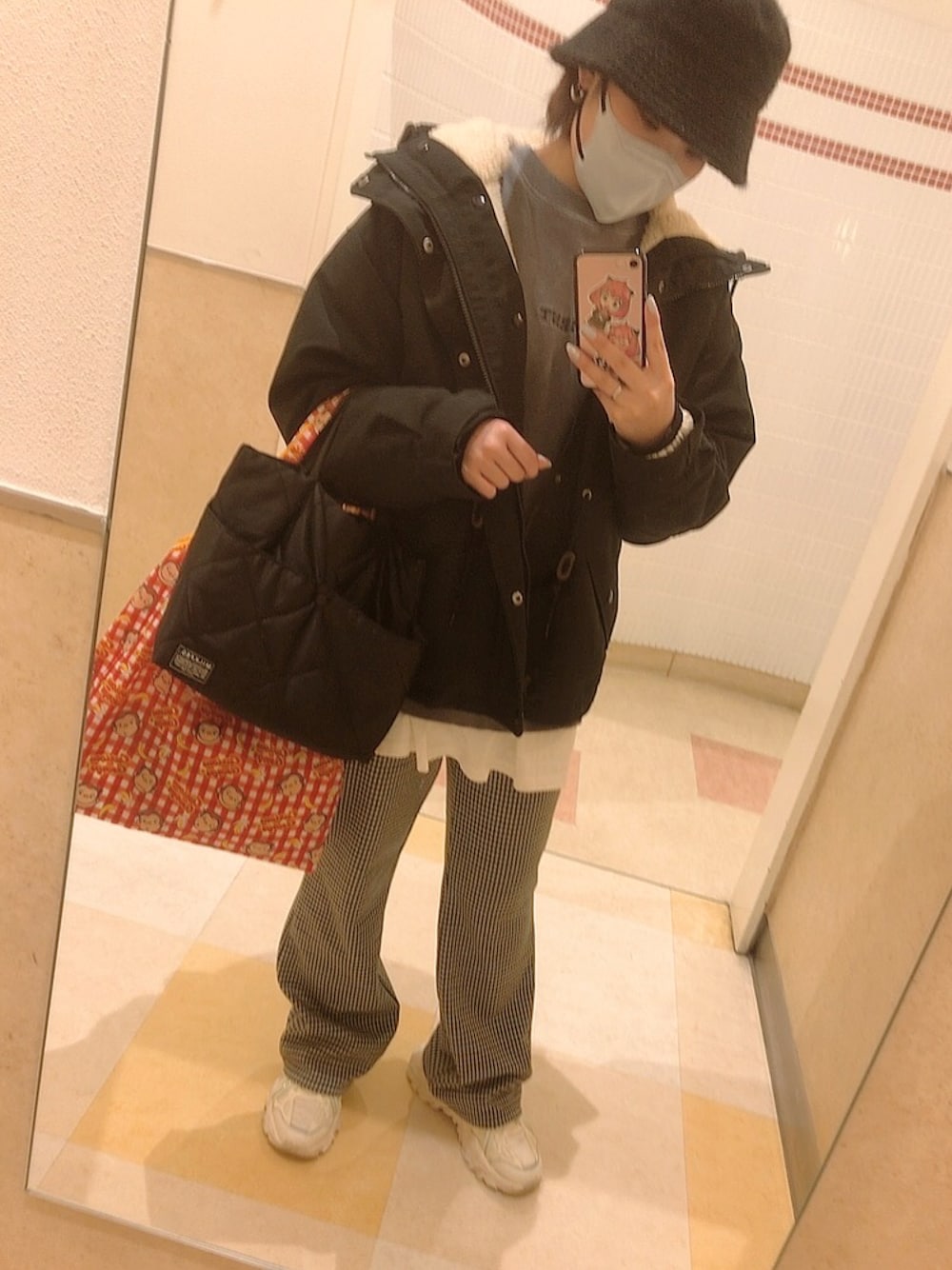 ホワイト系のスニーカー、ブラック系のパンツ、ブラック系のバッグを着用したレディースの冬コーディネートの1枚目の写真