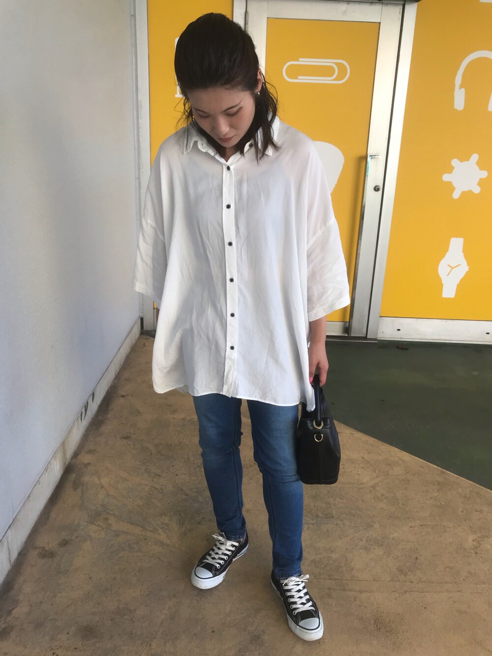 ブラック系のスニーカー、ブラック系のショルダーバッグ、ホワイト系のシャツ/ブラウスを着用したレディースの秋コーディネートの1枚目の写真