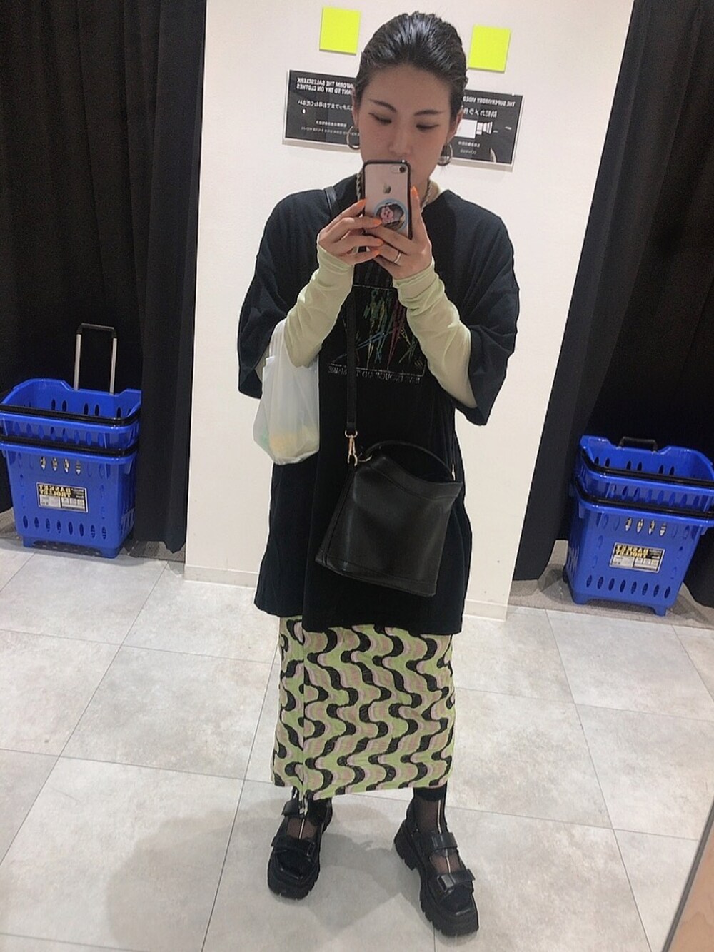 ブラック系のサンダル、イエロー系のスカート、ブラック系のショルダーバッグを着用したレディースの春コーディネートの1枚目の写真