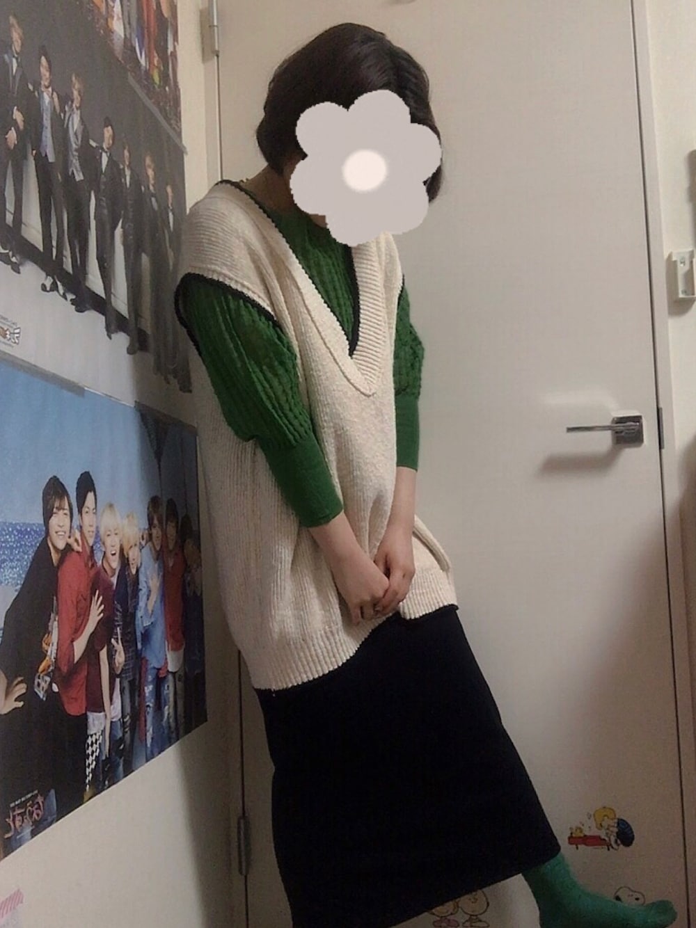 ブラック系のスカート、ホワイト系のベスト、グリーン系のニット/セーターを着用したレディースの春コーディネートの1枚目の写真