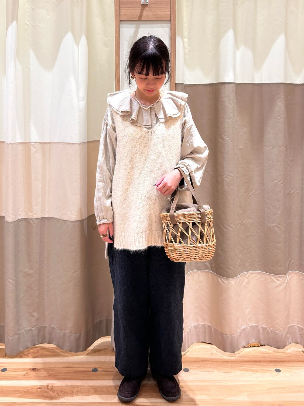 ホワイト系のベスト、ベージュ系のシャツ/ブラウス、ベージュ系のハンドバッグを着用したレディースの秋コーディネートの1枚目の写真