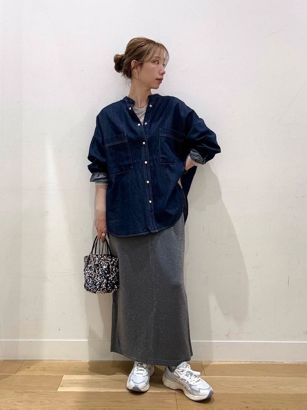 シルバー系のショルダーバッグ、グレー系のスカート、グレー系のTシャツ/カットソーを着用したレディースの冬コーディネートの1枚目の写真