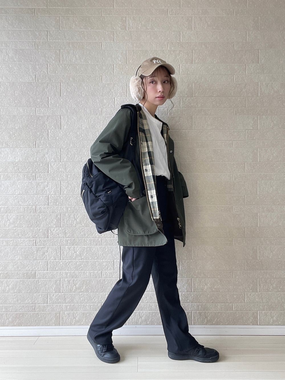 ブラック系のスラックス、グリーン系のブルゾン、ブラック系のスニーカーを着用したレディースの秋コーディネートの1枚目の写真