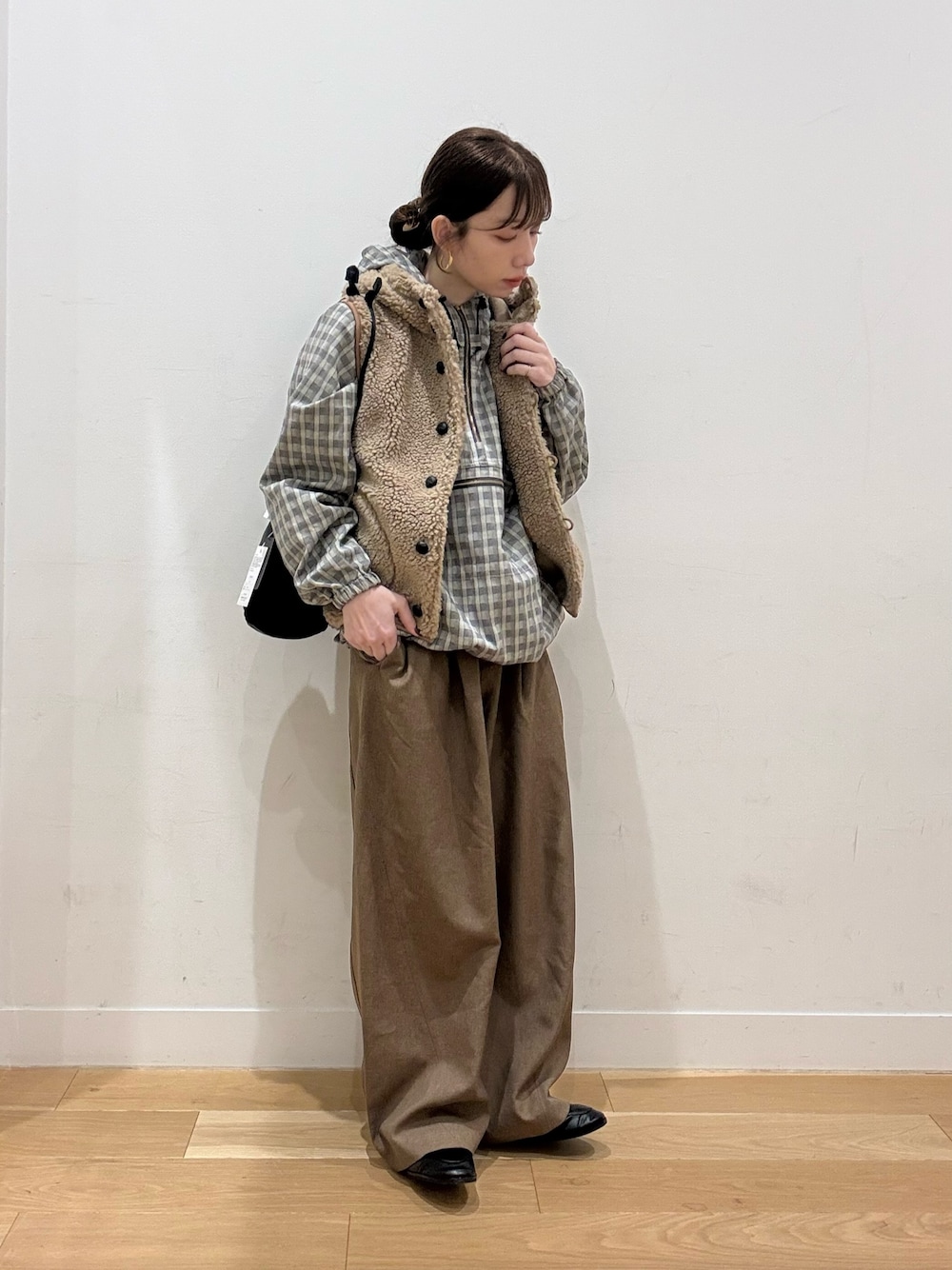 ベージュ系のダウンベスト、レッド系のTシャツ/カットソー、ブラック系のローファーを着用したレディースの秋コーディネートの1枚目の写真