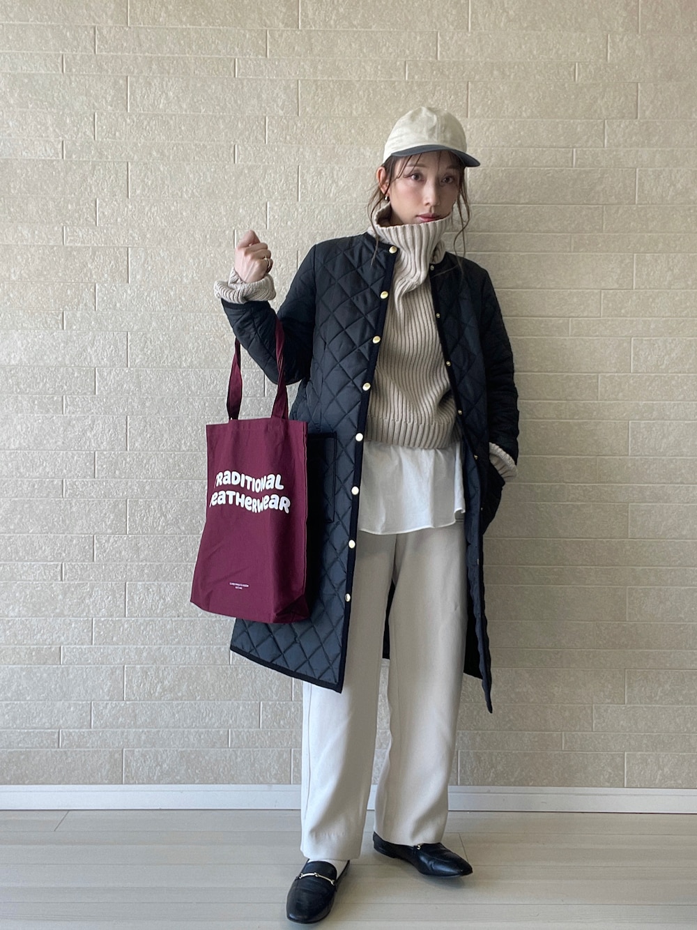 ブラック系のその他アウター、レッド系のトートバッグ、ブラウン系のニット/セーターを着用したレディースの秋コーディネートの1枚目の写真