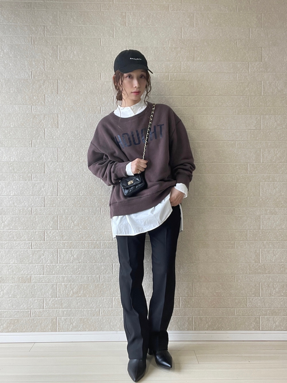 ブラック系のスラックス、ブラック系のブーツ、ブラウン系のスウェットを着用したレディースの秋コーディネートの1枚目の写真
