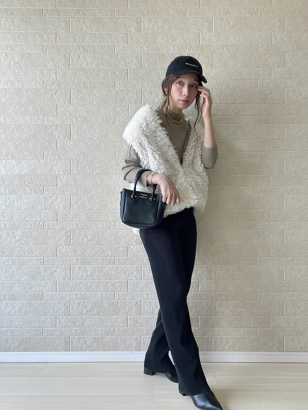 ブラック系のブーツ、ベージュ系のニット/セーター、ブラック系のその他パンツを着用したレディースの秋コーディネートの1枚目の写真