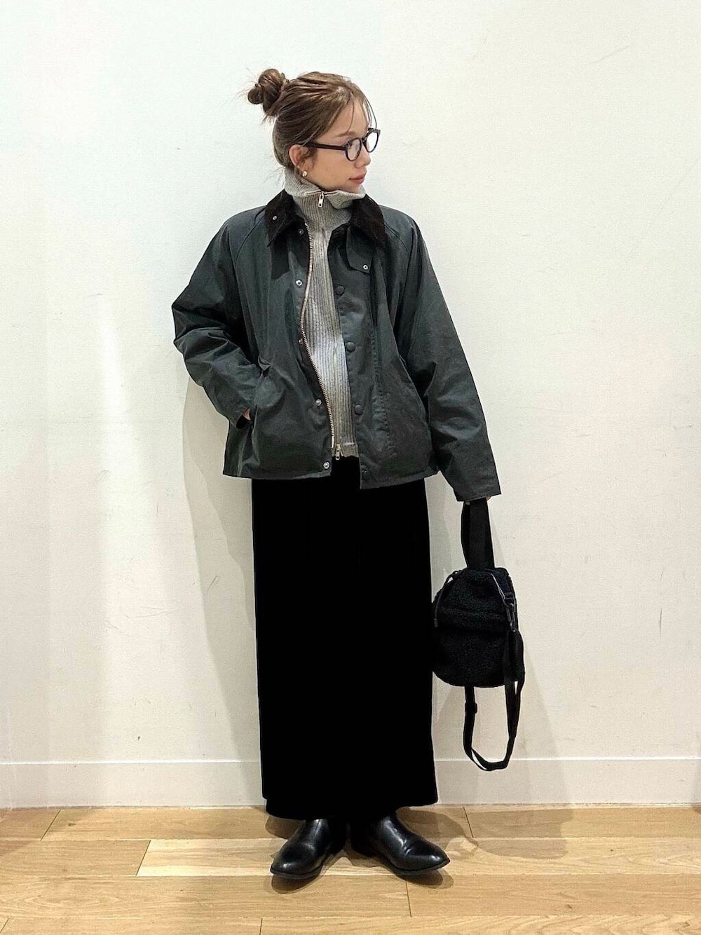 ブラック系のブーツ、グレー系のカーディガン/ボレロ、ブラック系のスカートを着用したレディースの冬コーディネートの1枚目の写真