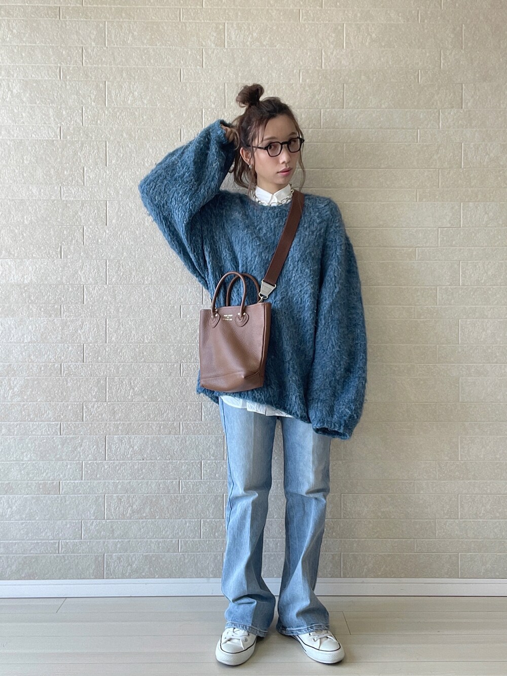 ブルー系のデニムパンツ、ホワイト系のシャツ/ブラウス、ブルー系のニット/セーターを着用したレディースの秋コーディネートの1枚目の写真