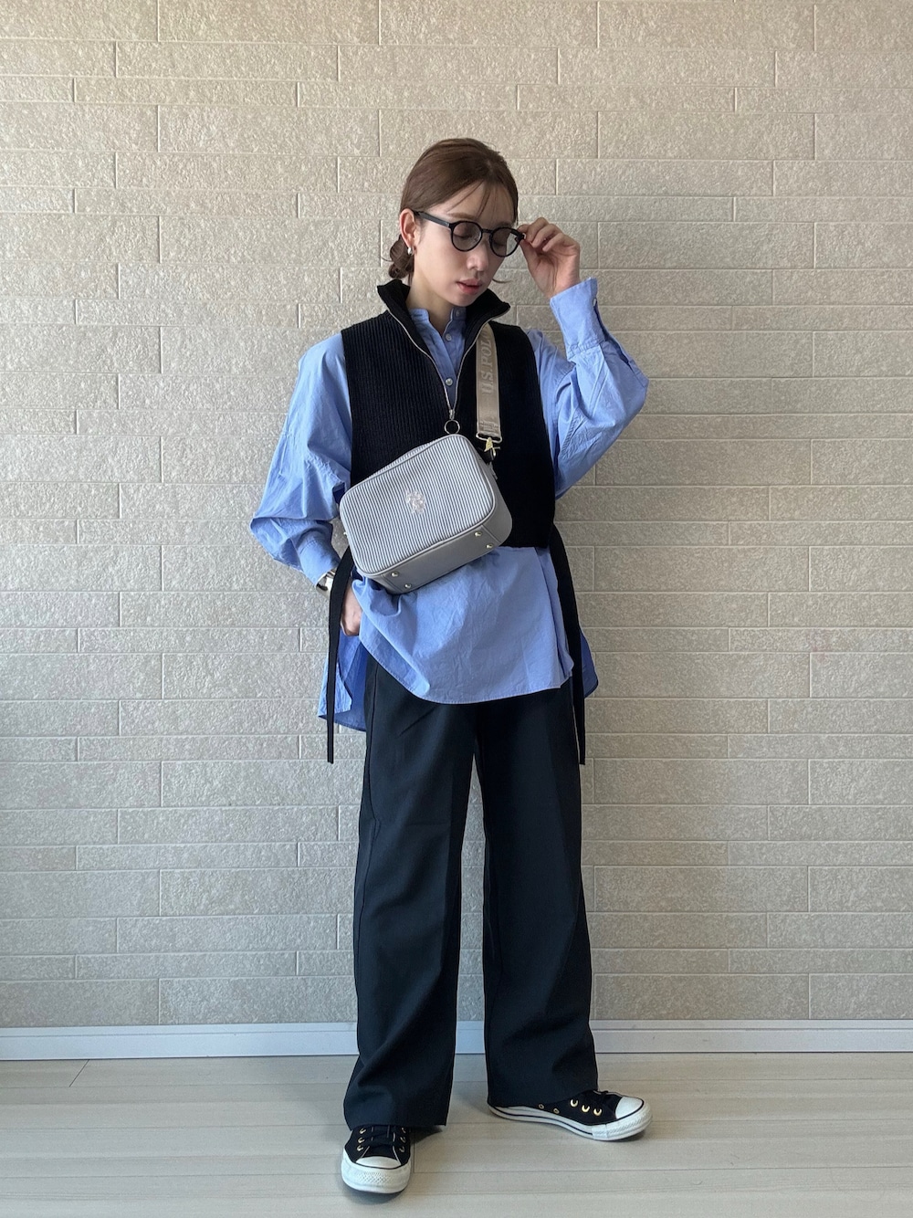 グレー系のショルダーバッグ、グレー系のその他パンツ、ブラック系のベストを着用したレディースの秋コーディネートの1枚目の写真