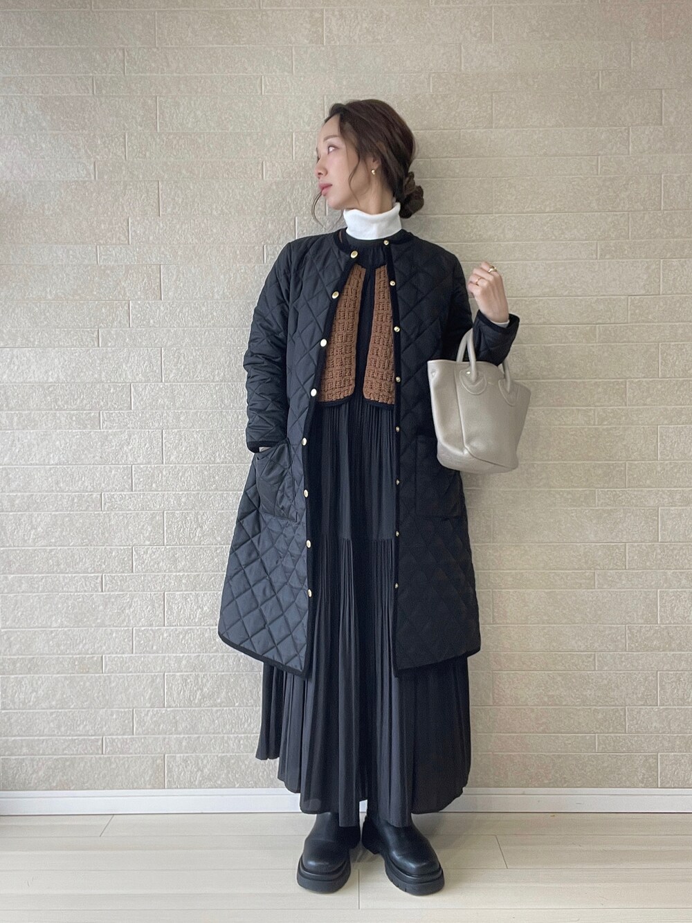 ブラック系のその他アウター、ブラウン系のベスト、ブラック系のブーツを着用したレディースの冬コーディネートの1枚目の写真