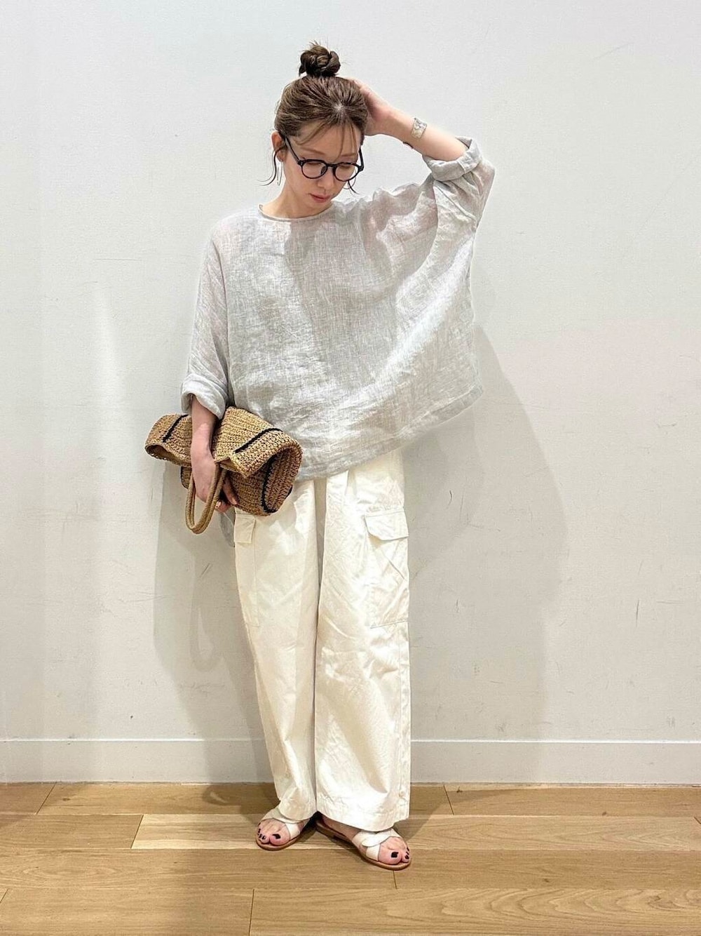 ベージュ系のトートバッグ、ホワイト系のサンダル、ベージュ系のタンクトップを着用したレディースの春コーディネートの1枚目の写真