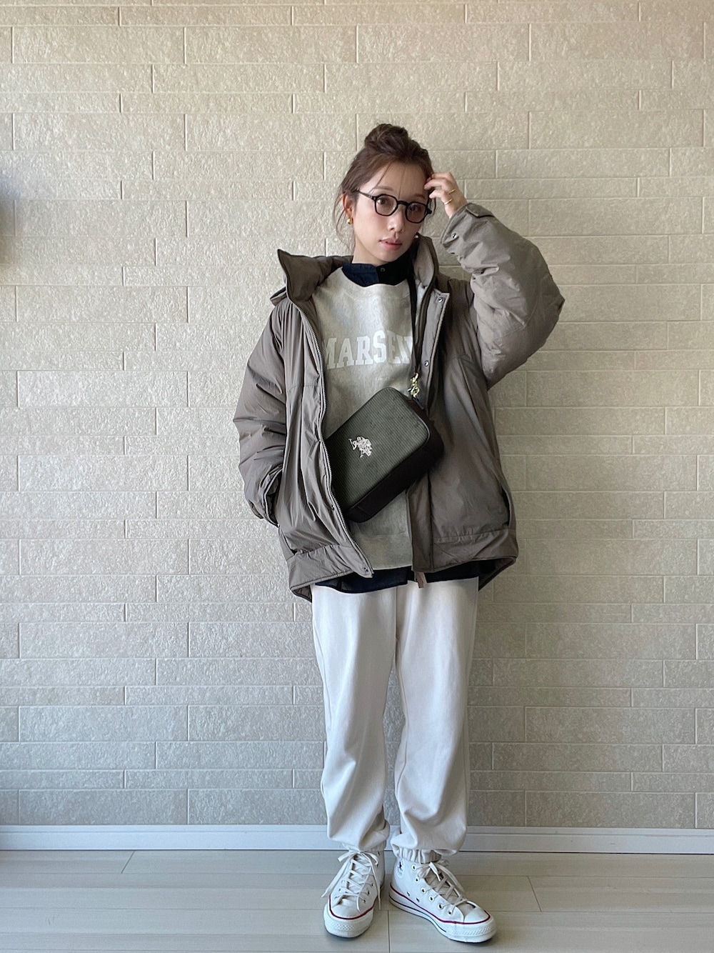 グリーン系のショルダーバッグ、ホワイト系のスニーカー、ベージュ系のスウェットを着用したレディースの冬コーディネートの1枚目の写真