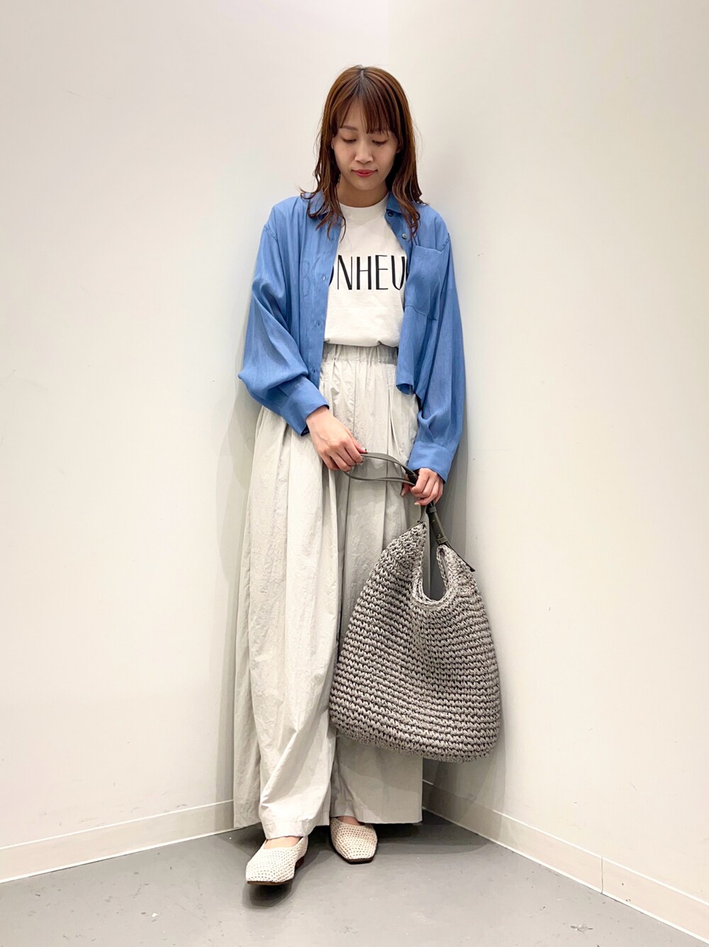 グレー系のトートバッグ、ホワイト系のその他シューズ、グレー系のその他パンツを着用したレディースの春コーディネートの1枚目の写真