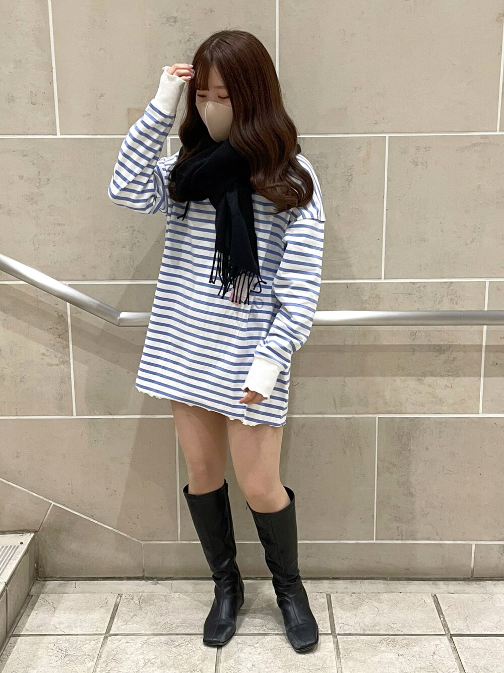 ブルー系のTシャツ/カットソー、ブラック系のブーツ、ブラック系のマフラーを着用したレディースの冬コーディネートの1枚目の写真