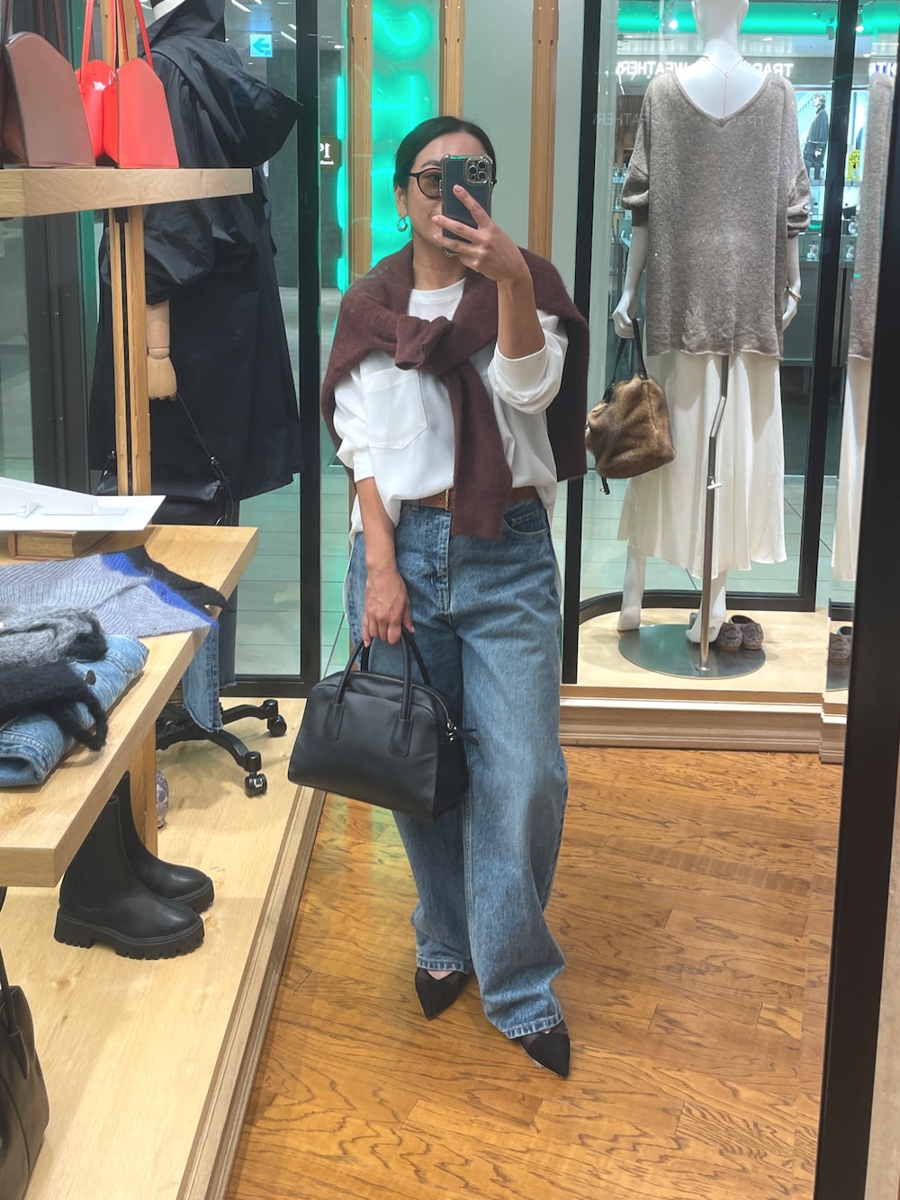 ホワイト系のシャツ/ブラウス、レッド系のニット/セーター、ブルー系のデニムパンツを着用したレディースの秋コーディネートの1枚目の写真