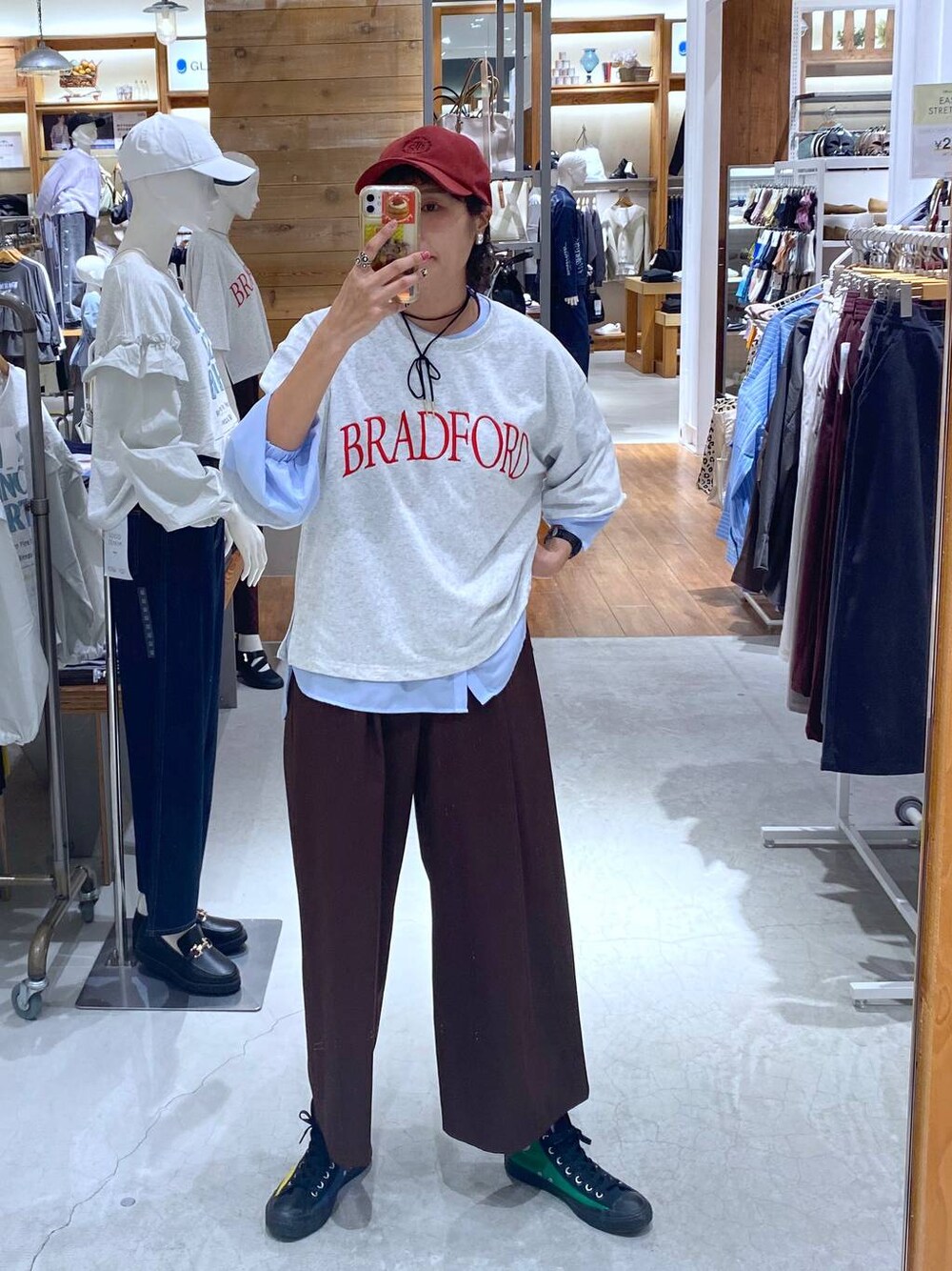 ブラウン系のその他パンツ、グレー系のシャツ/ブラウス、レッド系のキャップを着用したレディースの秋コーディネートの1枚目の写真