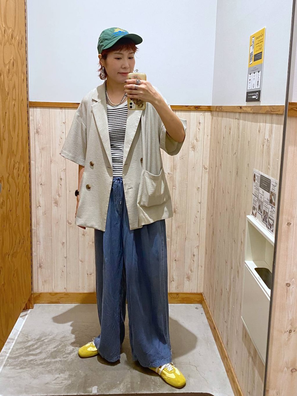 ベージュ系のテーラードジャケット、ブルー系のデニムパンツ、ブルー系のネックレスを着用したレディースの春コーディネートの1枚目の写真