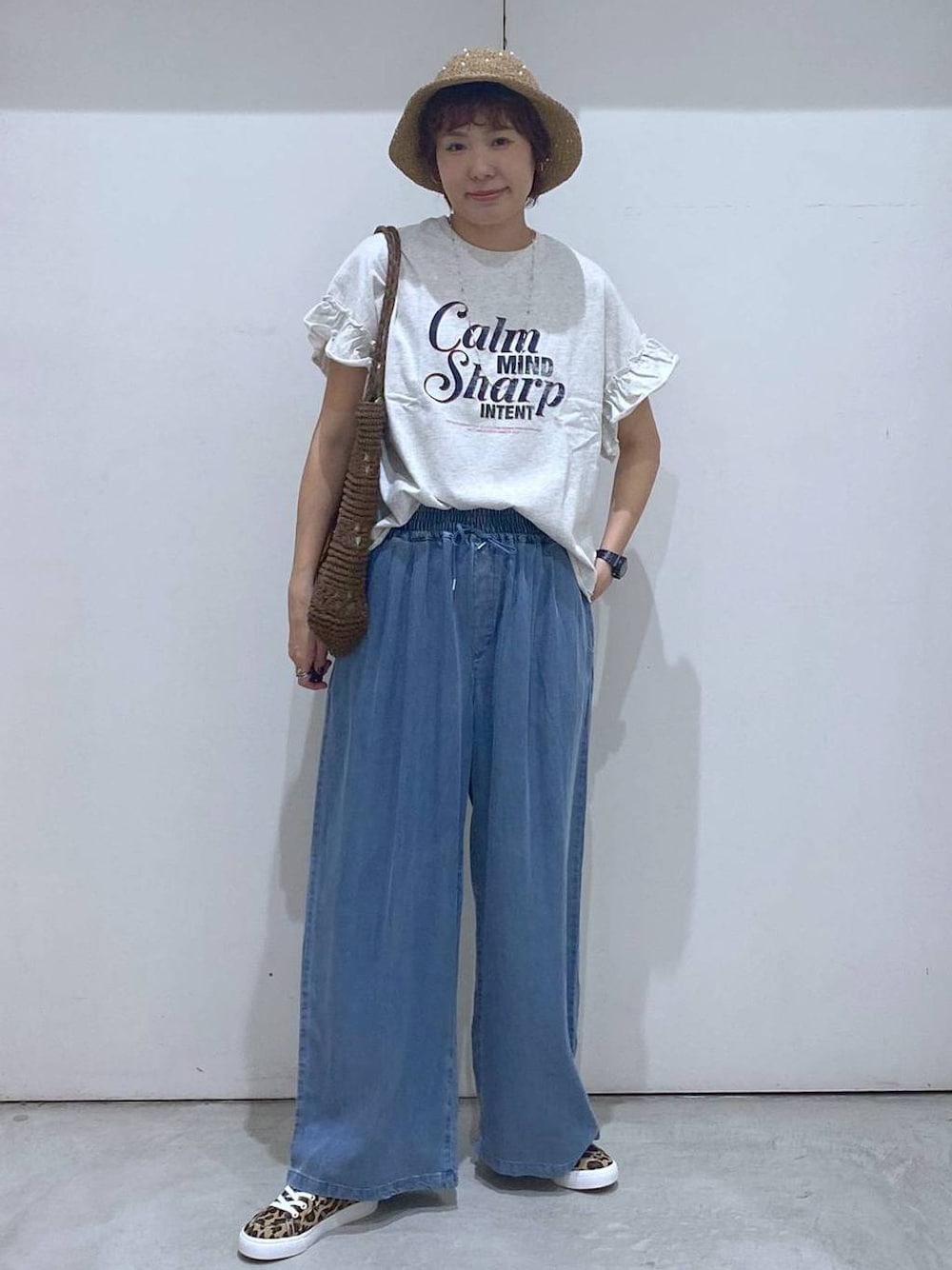 その他のスニーカー、ブルー系のデニムパンツ、ブラウン系のトートバッグを着用したレディースの春コーディネートの1枚目の写真