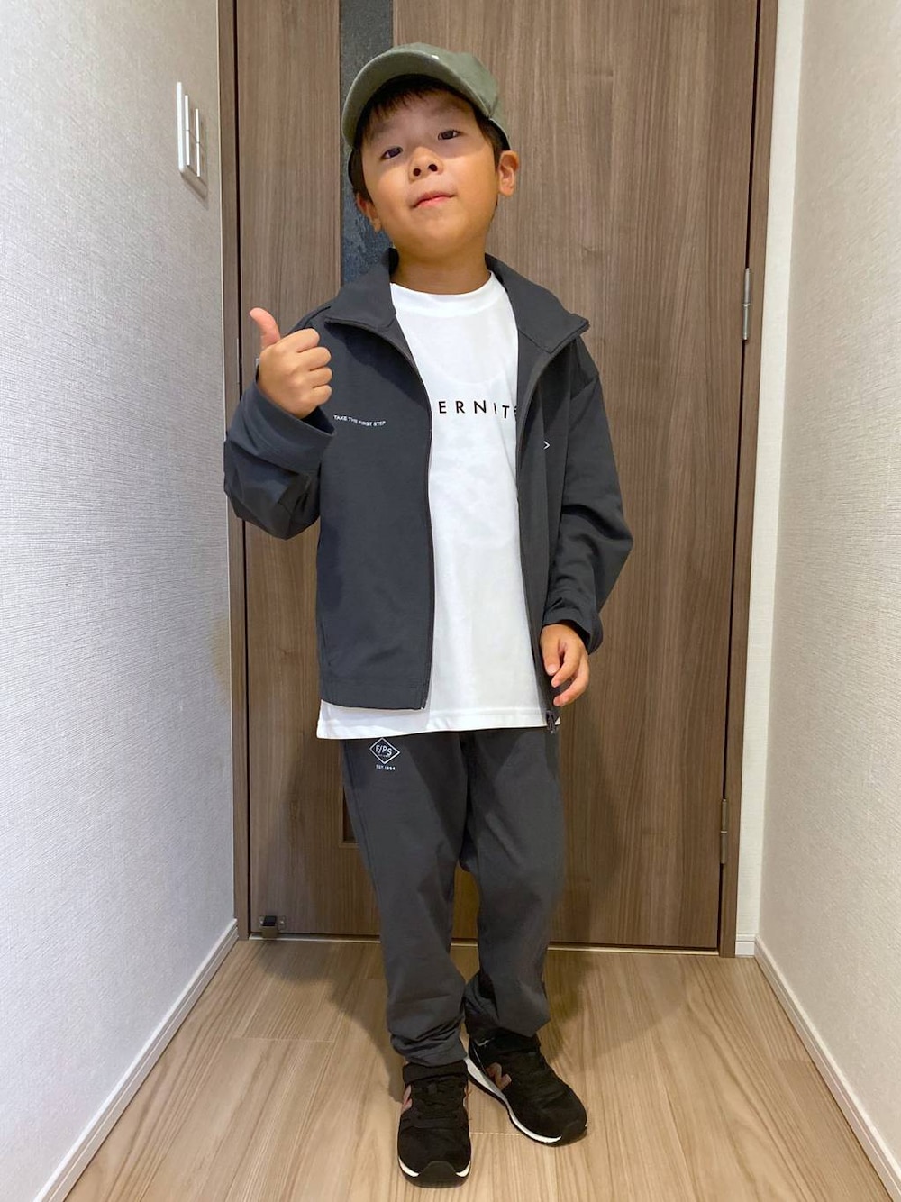 グレー系のブルゾン、ホワイト系のTシャツ/カットソー、グレー系のその他パンツを着用したキッズの秋コーディネートの1枚目の写真