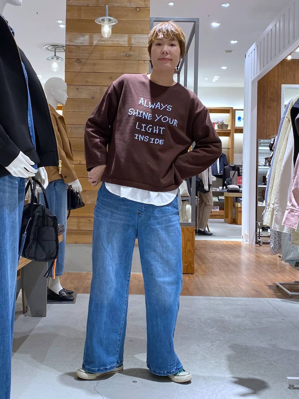 ブルー系のデニムパンツ、ブラウン系のニット/セーターを着用したレディースの冬コーディネートの1枚目の写真