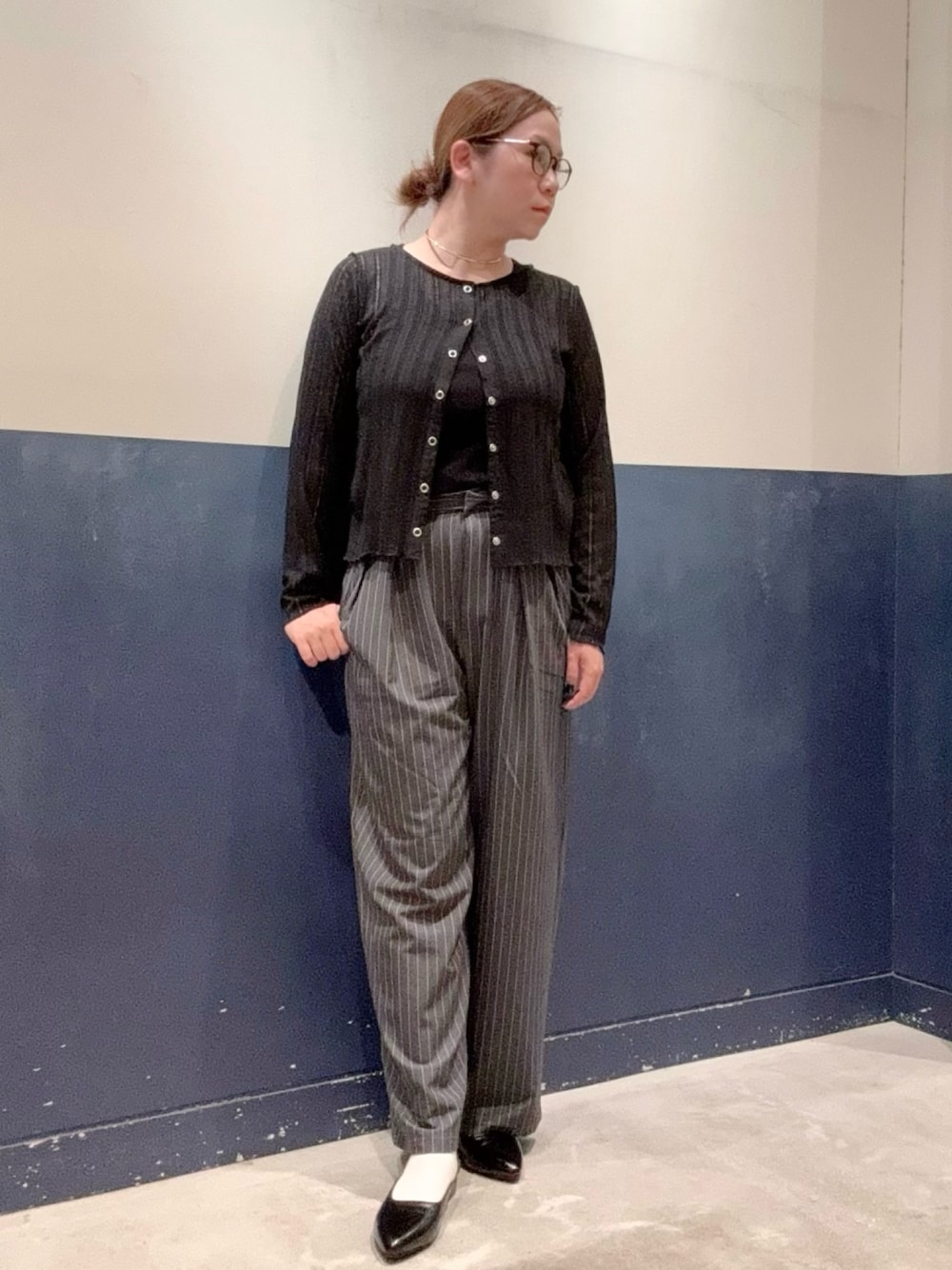 ブラック系のパンプス、グレー系のスラックス、ブラック系のタンクトップを着用したレディースの秋コーディネートの1枚目の写真