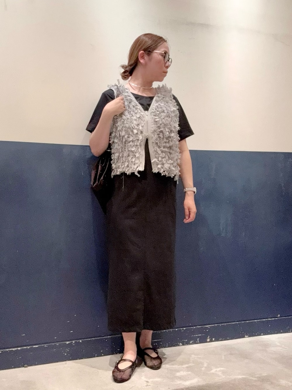 ブラック系のワンピース、ブラック系のパンプス、グレー系のベストを着用したレディースの夏コーディネートの1枚目の写真