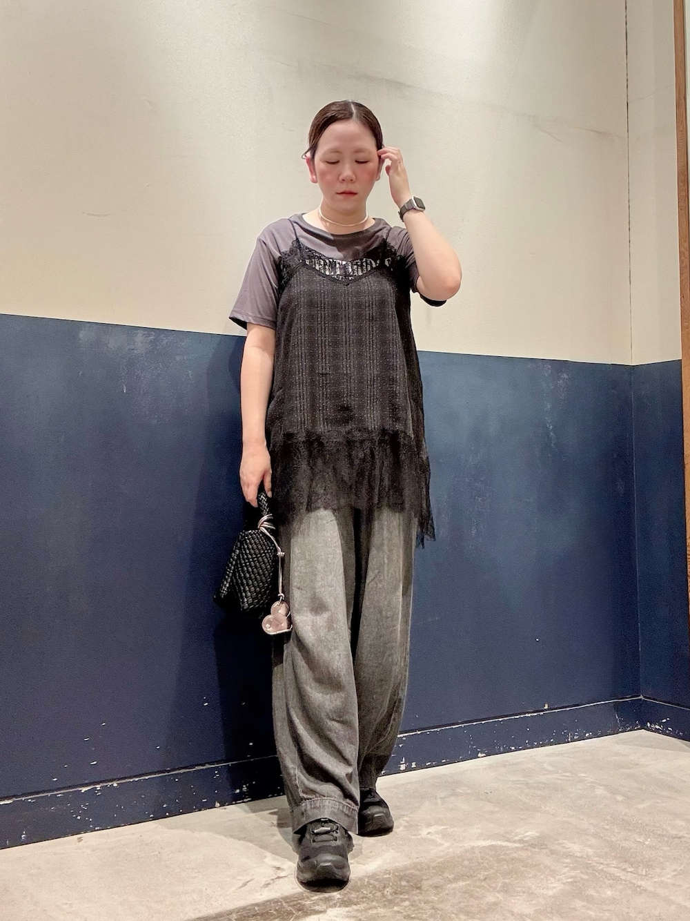 ブラック系のデニムパンツ、ブラック系のショルダーバッグ、ブラック系のチュニックを着用したレディースの夏コーディネートの1枚目の写真
