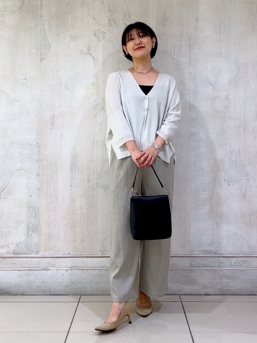 グレー系のその他パンツ、シルバー系のカーディガン/ボレロ、ブラック系のショルダーバッグを着用したレディースの秋コーディネートの1枚目の写真