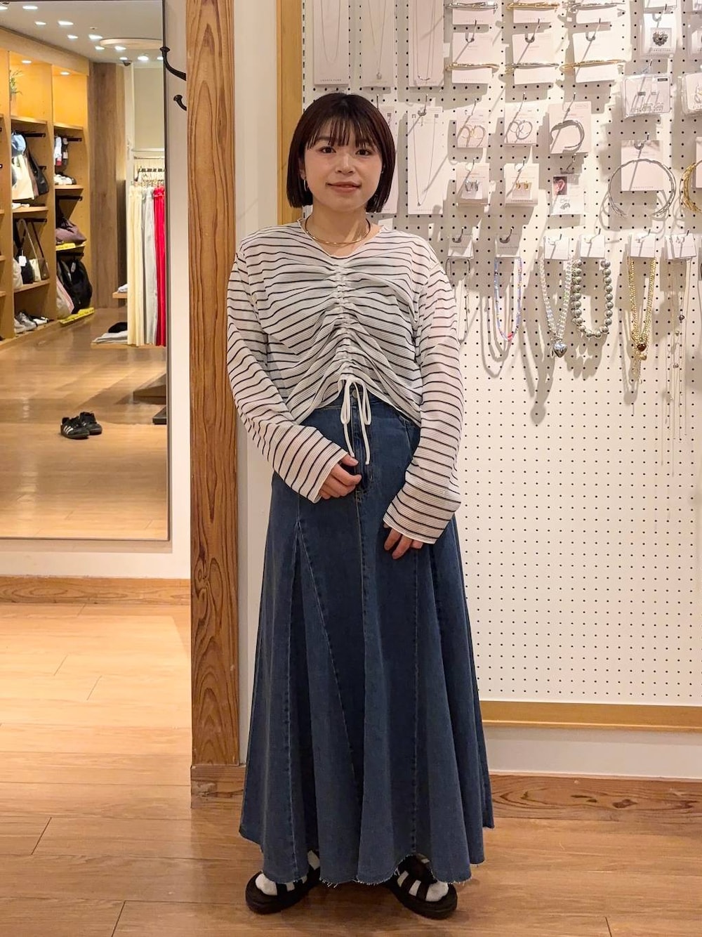 ブラック系のサンダル、その他のTシャツ/カットソー、ブルー系のスカートを着用したレディースの春コーディネートの1枚目の写真
