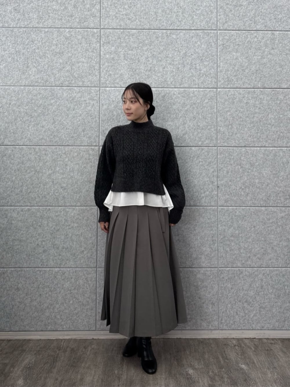グレー系のスカート、グレー系のニット/セーターを着用したレディースの秋コーディネートの1枚目の写真