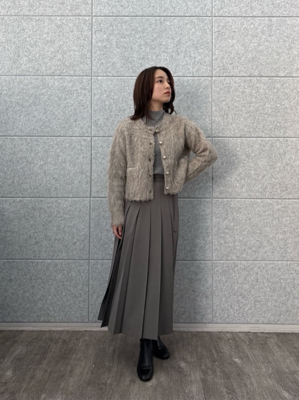 ブラウン系のニット/セーター、ベージュ系のカーディガン/ボレロ、グレー系のスカートを着用したレディースの秋コーディネートの1枚目の写真