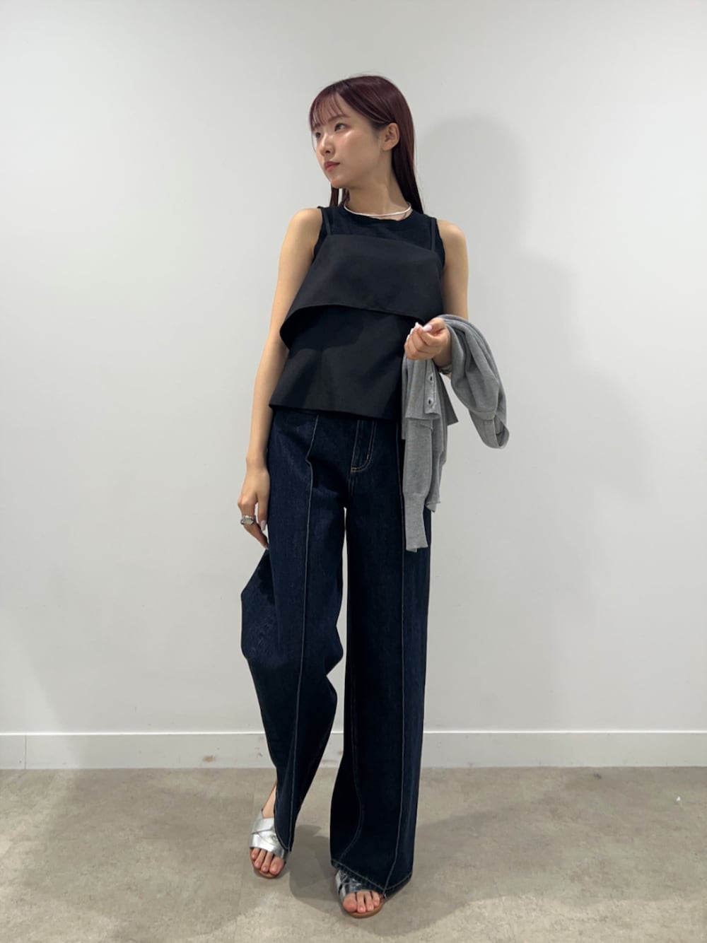 ブルー系のデニムパンツ、グレー系のカーディガン/ボレロ、ブラック系のシャツ/ブラウスを着用したレディースの春コーディネートの1枚目の写真