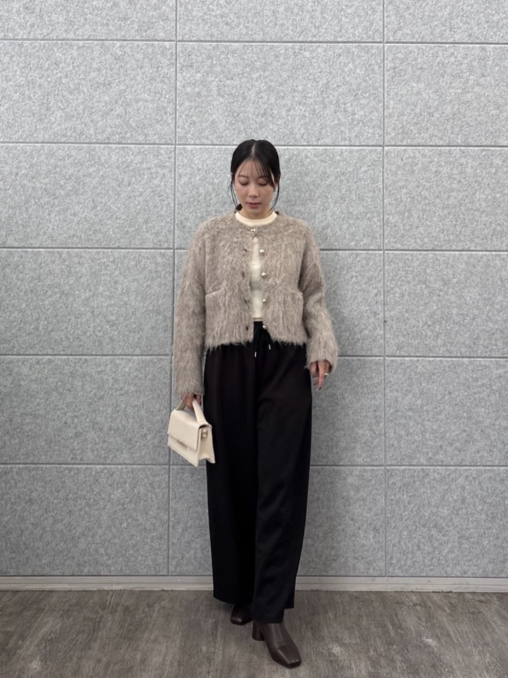 ブラック系のその他パンツ、ホワイト系のニット/セーター、ベージュ系のカーディガン/ボレロを着用したレディースの秋コーディネートの1枚目の写真
