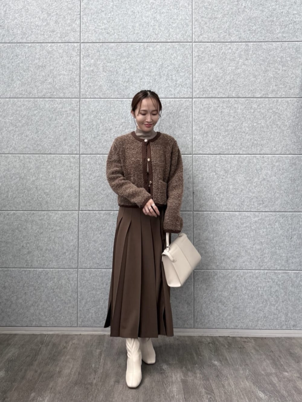 ブラウン系のスカート、ブラウン系のカーディガン/ボレロ、ブラウン系のニット/セーターを着用したレディースの秋コーディネートの1枚目の写真
