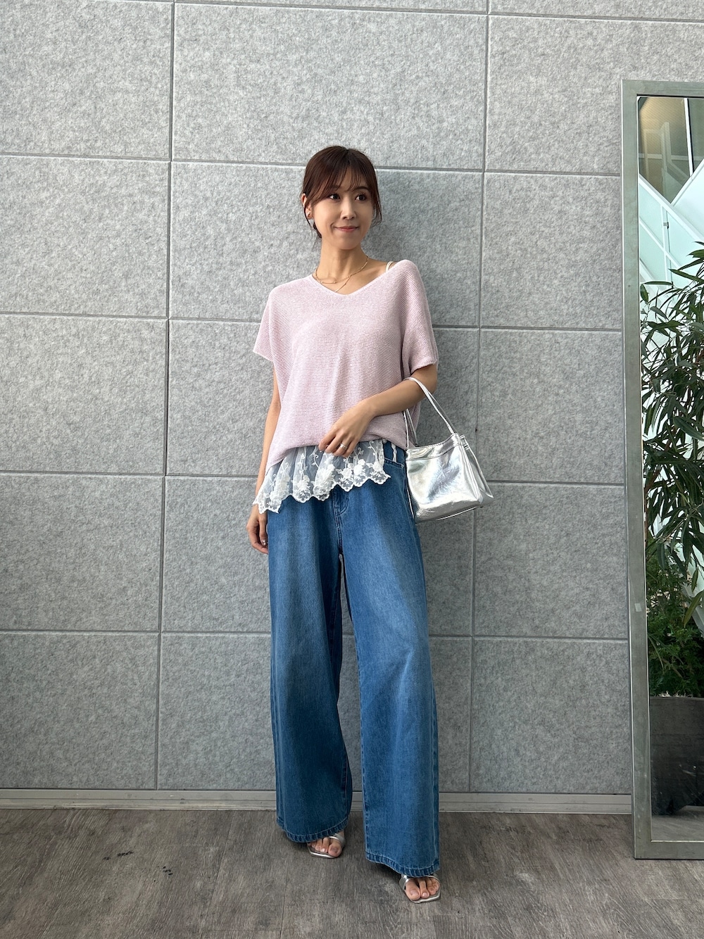 パープル系のニット/セーター、ブルー系のデニムパンツを着用したレディースの夏コーディネートの1枚目の写真