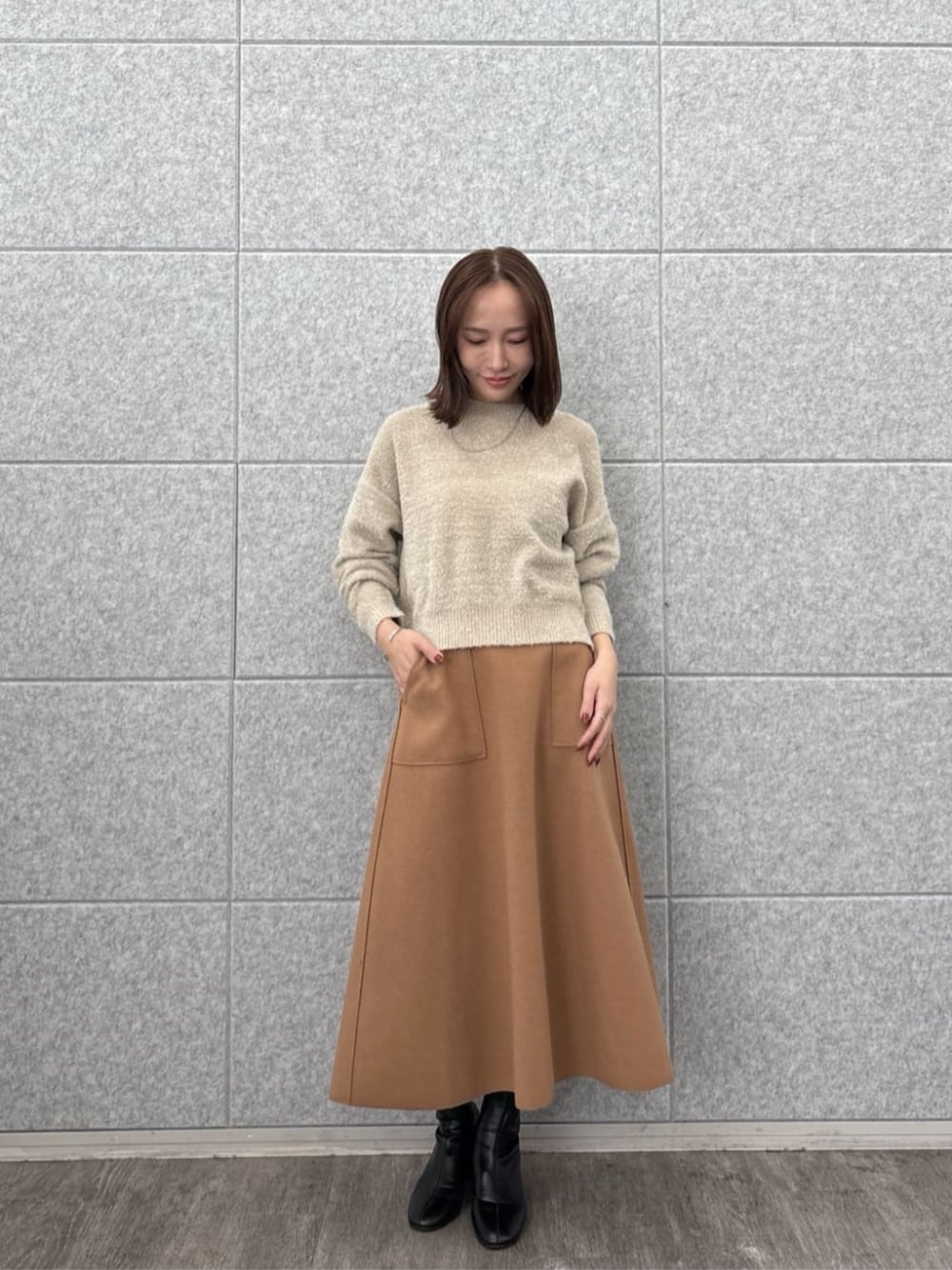 ベージュ系のニット/セーター、イエロー系のスカートを着用したレディースの秋コーディネートの1枚目の写真