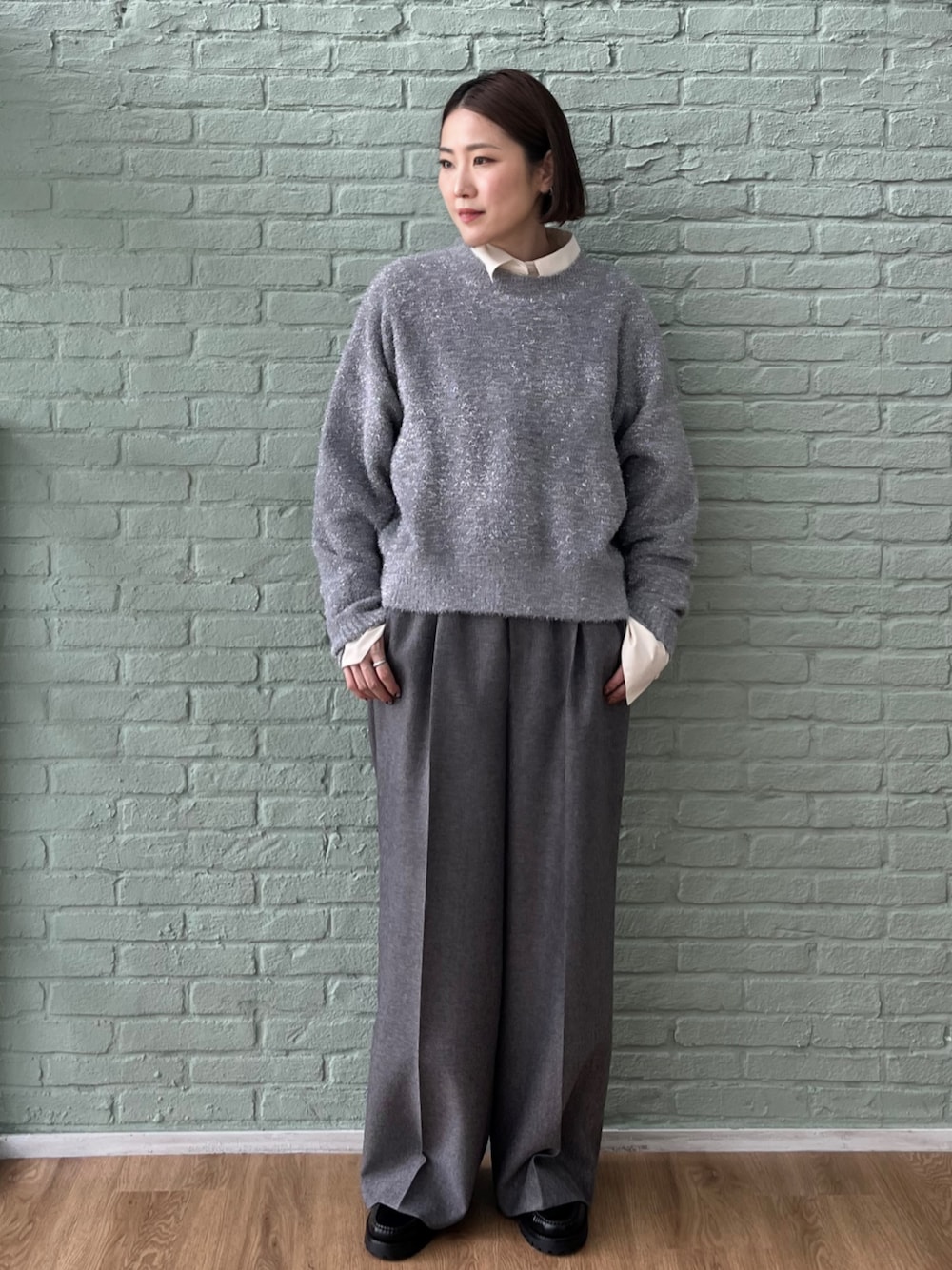 グレー系のその他パンツ、グレー系のニット/セーター、ホワイト系のシャツ/ブラウスを着用したレディースの秋コーディネートの1枚目の写真