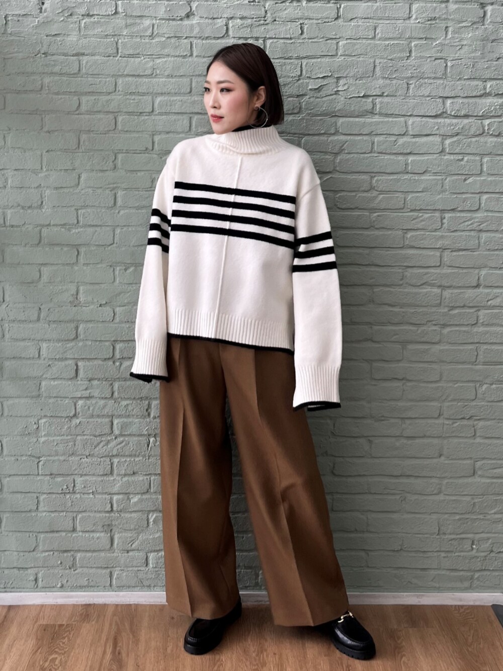 イエロー系のその他パンツ、ベージュ系のニット/セーターを着用したレディースの秋コーディネートの1枚目の写真