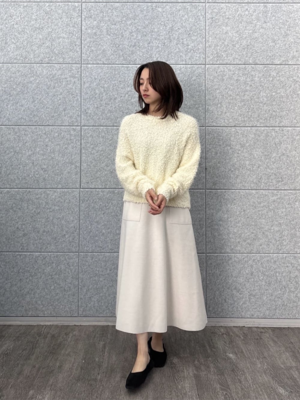 ホワイト系のニット/セーター、ホワイト系のスカートを着用したレディースの冬コーディネートの1枚目の写真