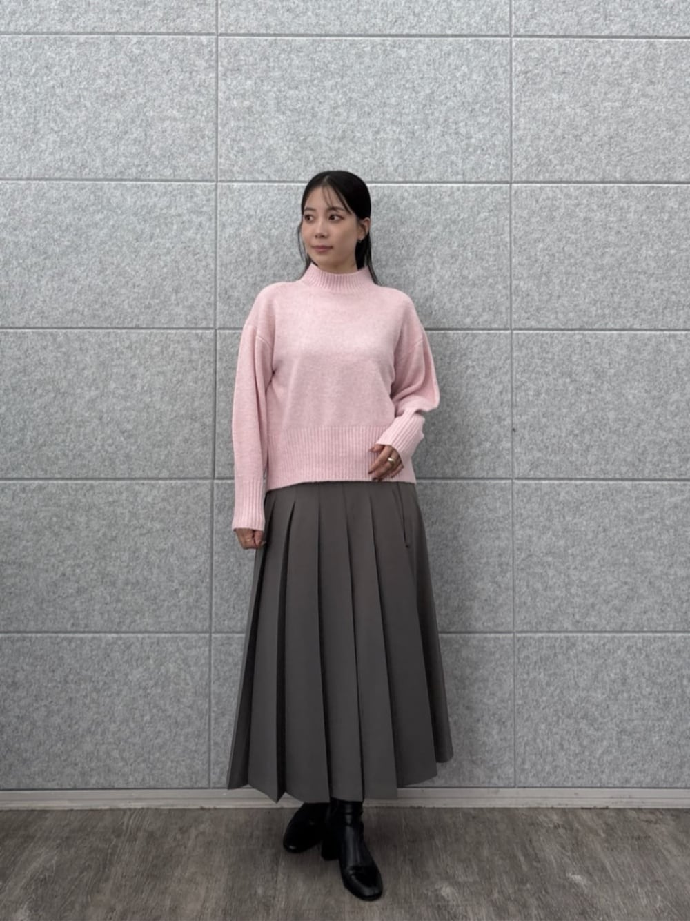 グレー系のスカート、ピンク系のニット/セーターを着用したレディースの秋コーディネートの1枚目の写真