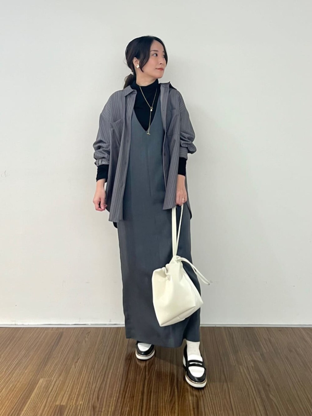 グレー系のシャツ/ブラウス、グレー系のワンピース、ブラック系のTシャツ/カットソーを着用したレディースの秋コーディネートの1枚目の写真