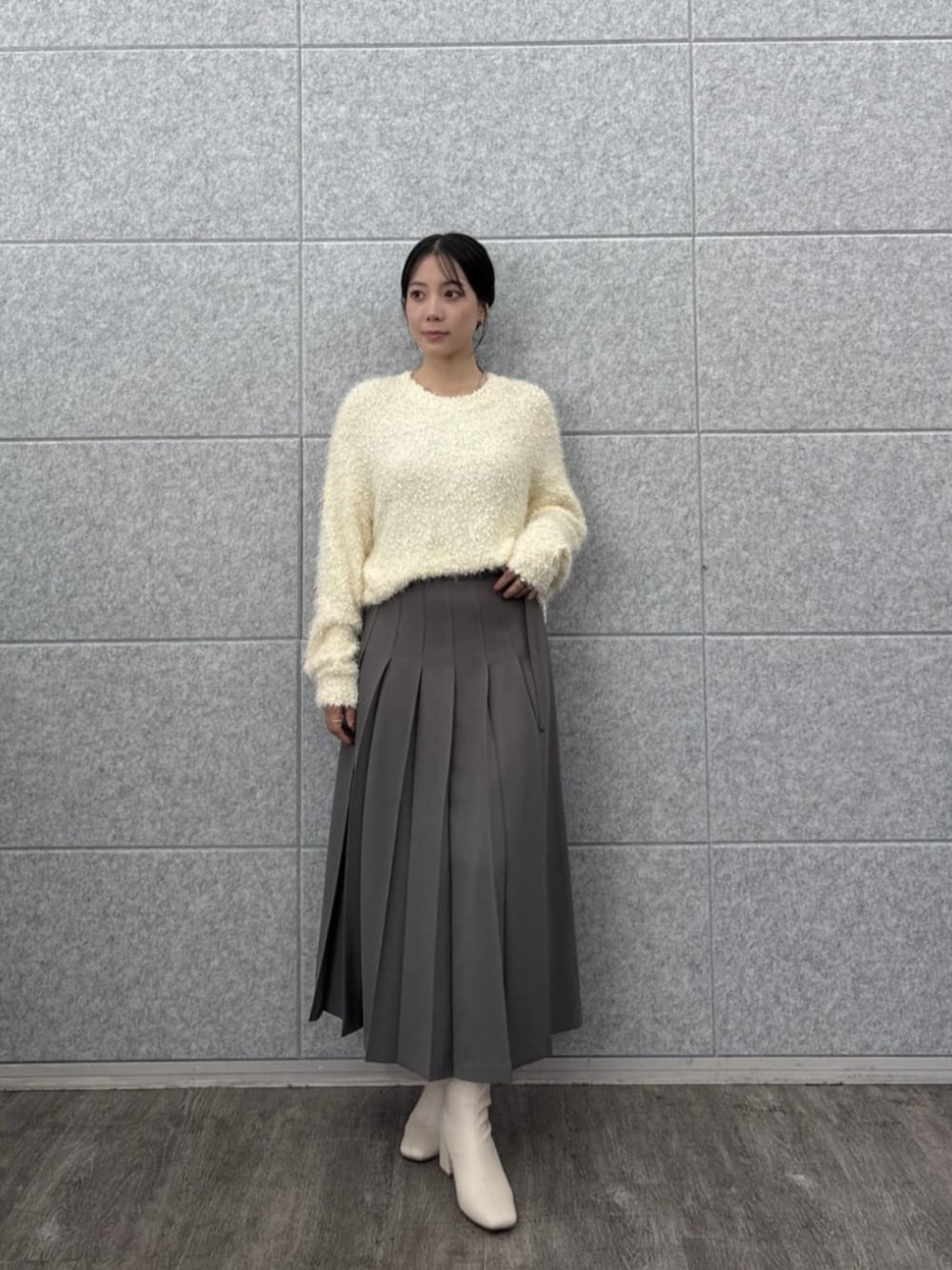 ホワイト系のニット/セーター、グレー系のスカートを着用したレディースの秋コーディネートの1枚目の写真