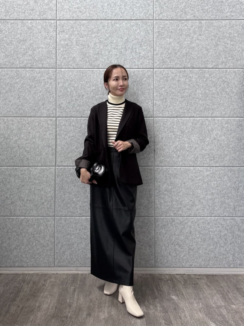 ブラック系のテーラードジャケット、ホワイト系のニット/セーターを着用したレディースの秋コーディネートの1枚目の写真