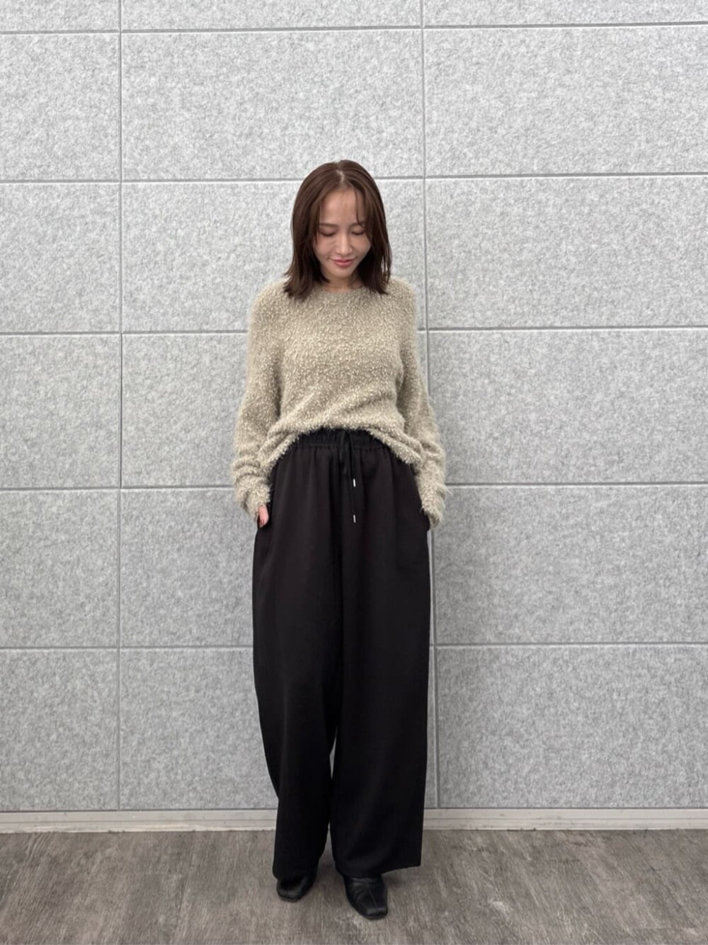 ブラック系のその他パンツ、ベージュ系のニット/セーターを着用したレディースの秋コーディネートの1枚目の写真