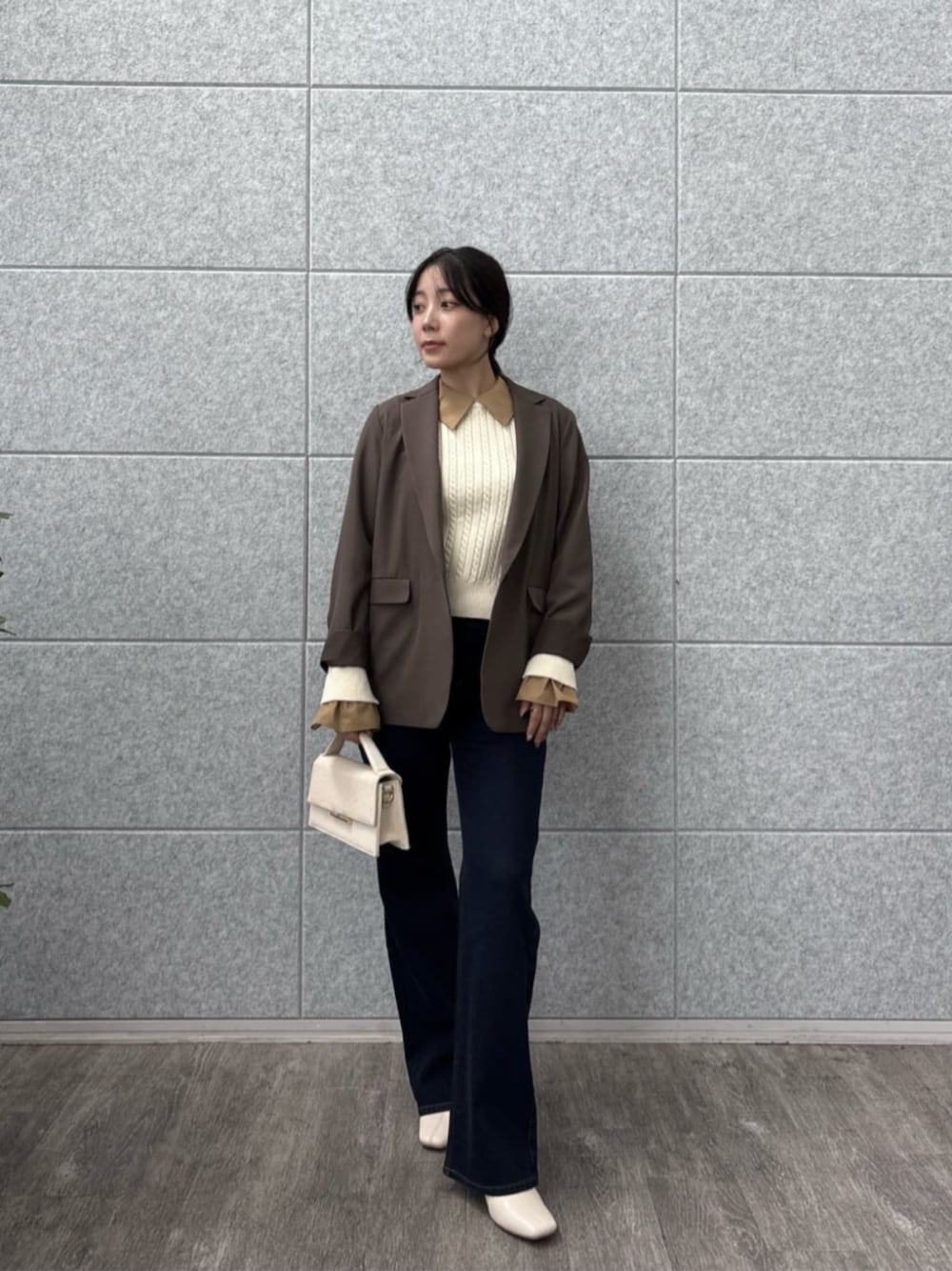 ブラウン系のテーラードジャケット、ブルー系のデニムパンツ、ホワイト系のニット/セーターを着用したレディースの秋コーディネートの1枚目の写真