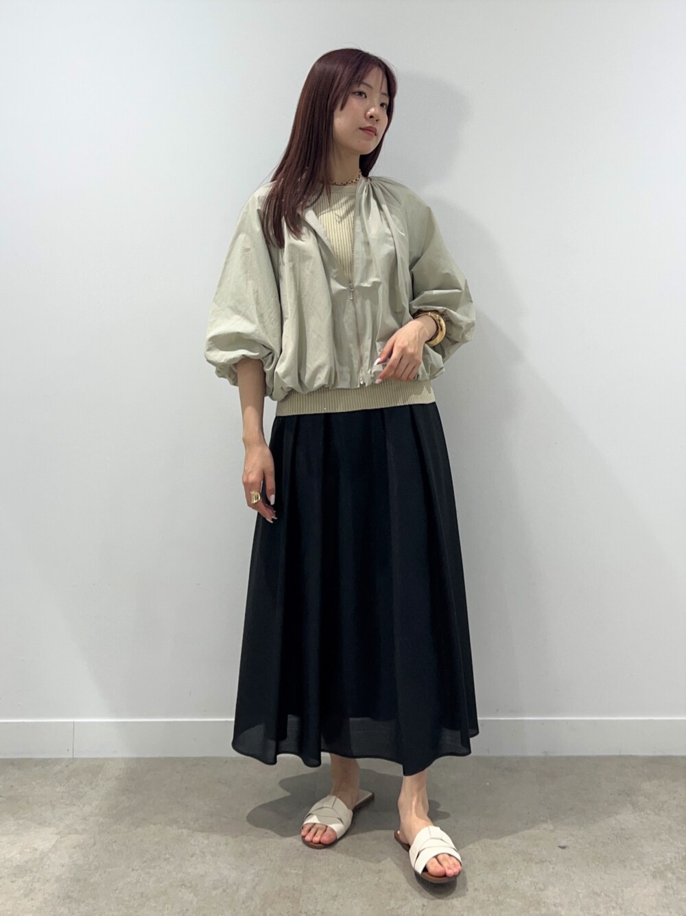 ベージュ系のブルゾン、ベージュ系のニット/セーター、ブラック系のスカートを着用したレディースの春コーディネートの1枚目の写真