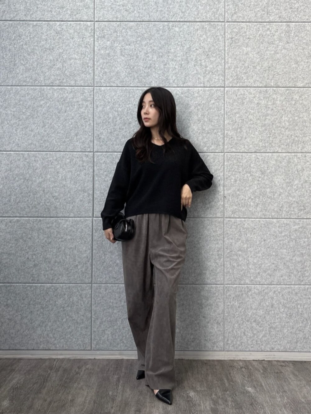 グレー系のその他パンツ、ブラック系のニット/セーターを着用したレディースの秋コーディネートの1枚目の写真