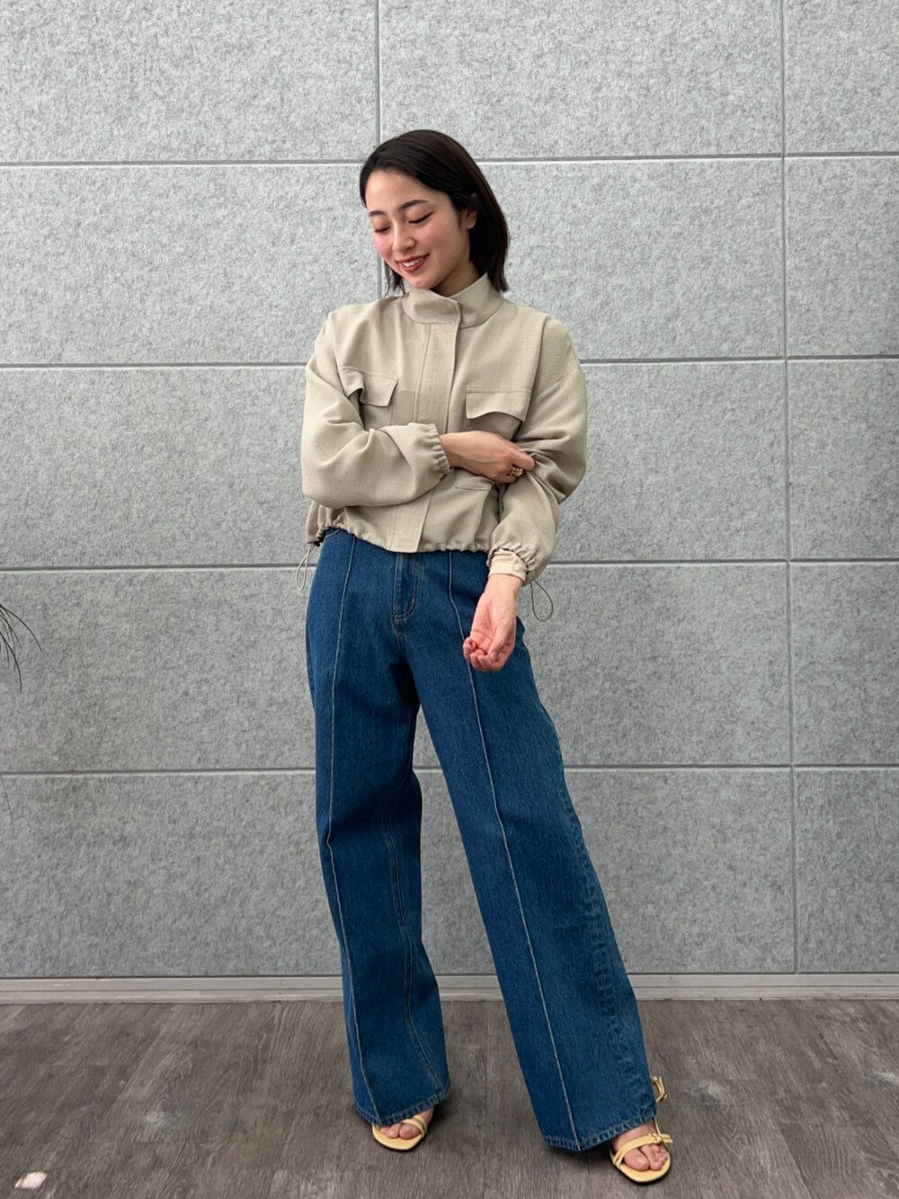 ブルー系のデニムパンツ、グリーン系のブルゾンを着用したレディースの春コーディネートの1枚目の写真