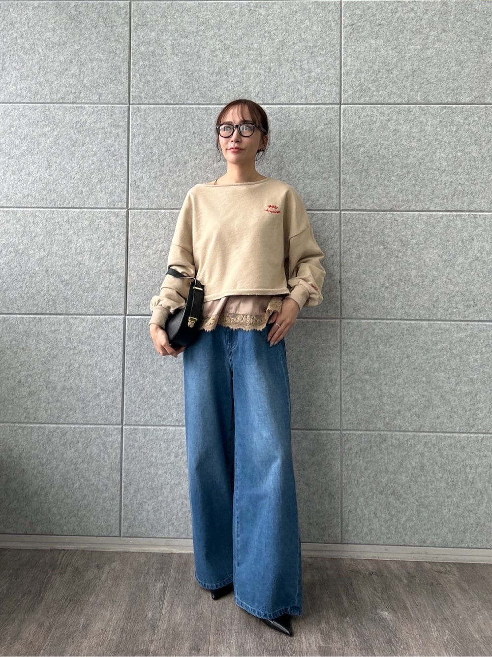 ベージュ系のスウェット、ブルー系のデニムパンツを着用したレディースの冬コーディネートの1枚目の写真